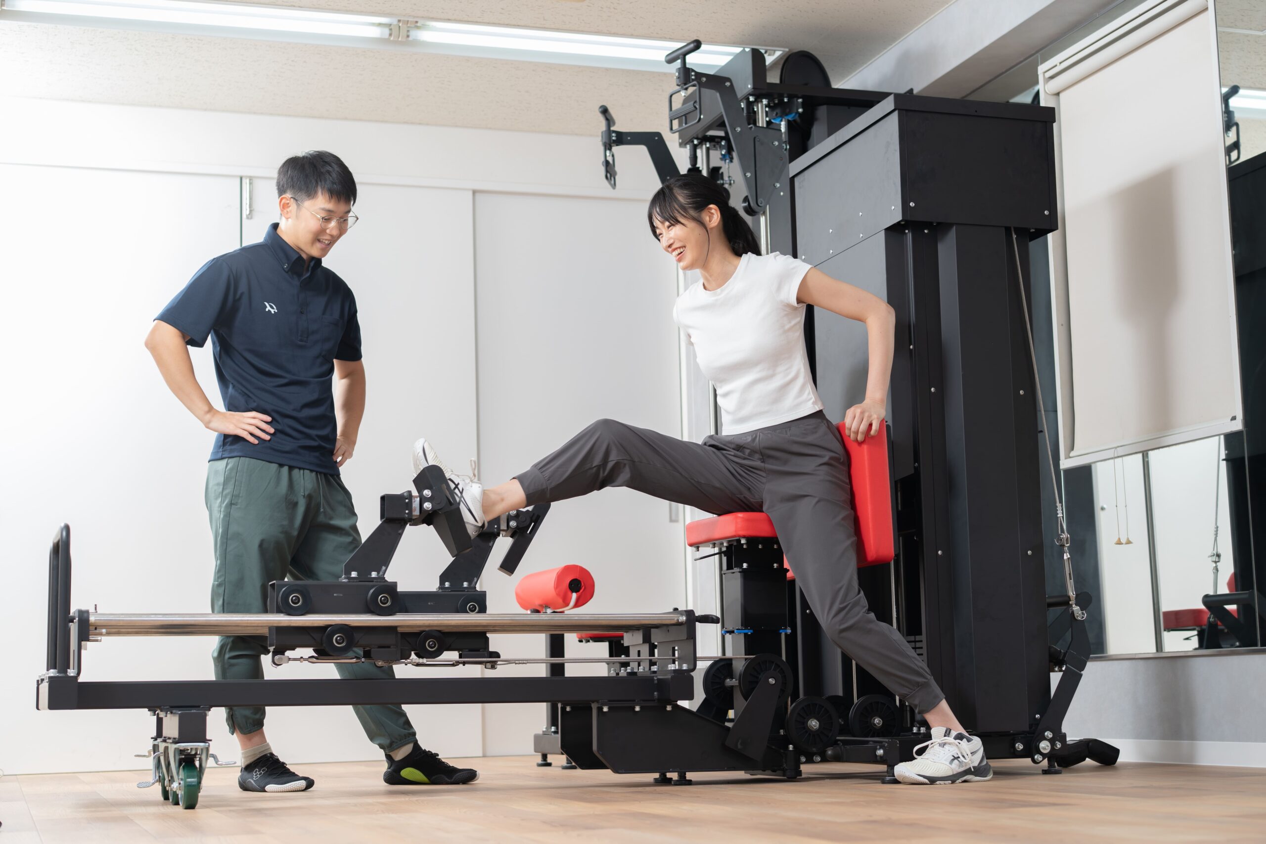 マシンを使ったエクササイズをトレーナーが指導している様子